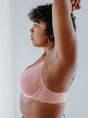 Woman wearing pink classic contour bra, side view, arms up