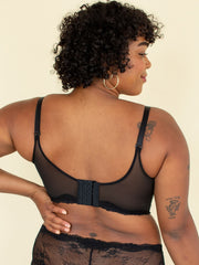 Woman wearing black longline bra, back view, hand on back