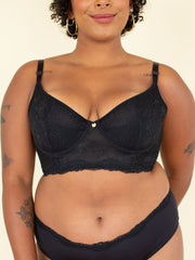 Woman wearing black longline bra, front view