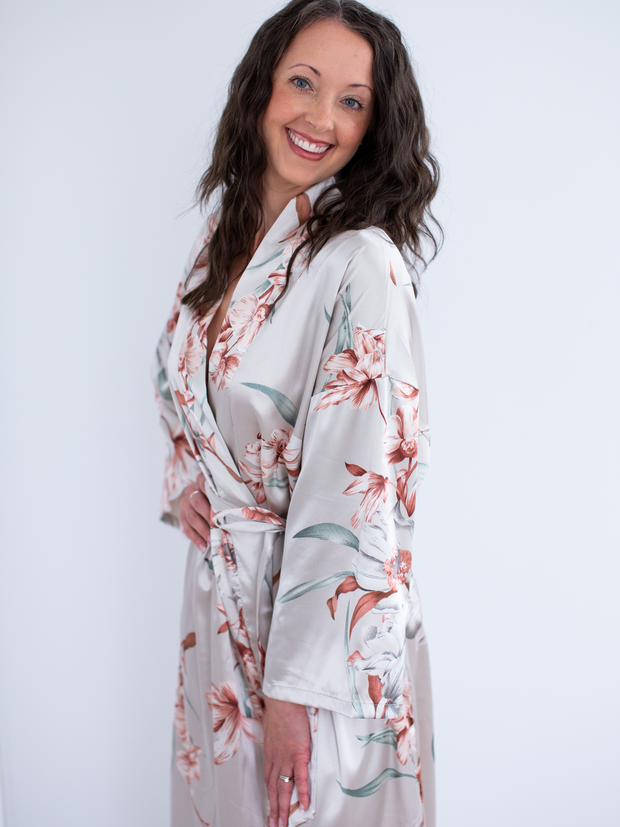Woman wearing satin robe in floral, turned showing sleeve