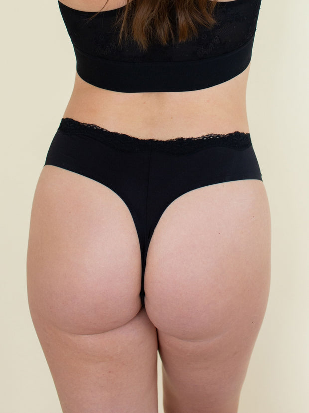 Woman wearing comfortable thong underwear in black, back