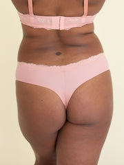 Woman wearing comfortable thong underwear in pink, back